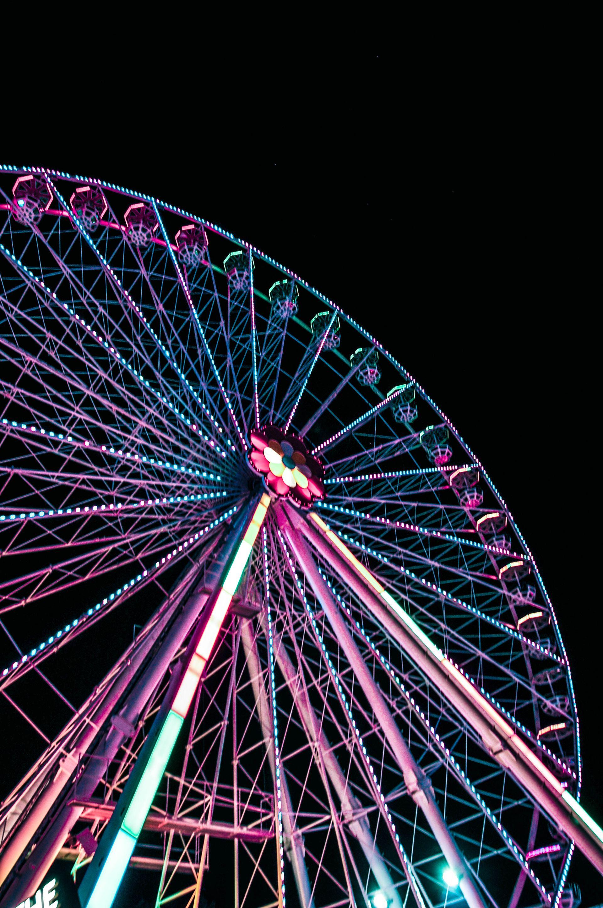 Illuminated ferris wheel against the night sky