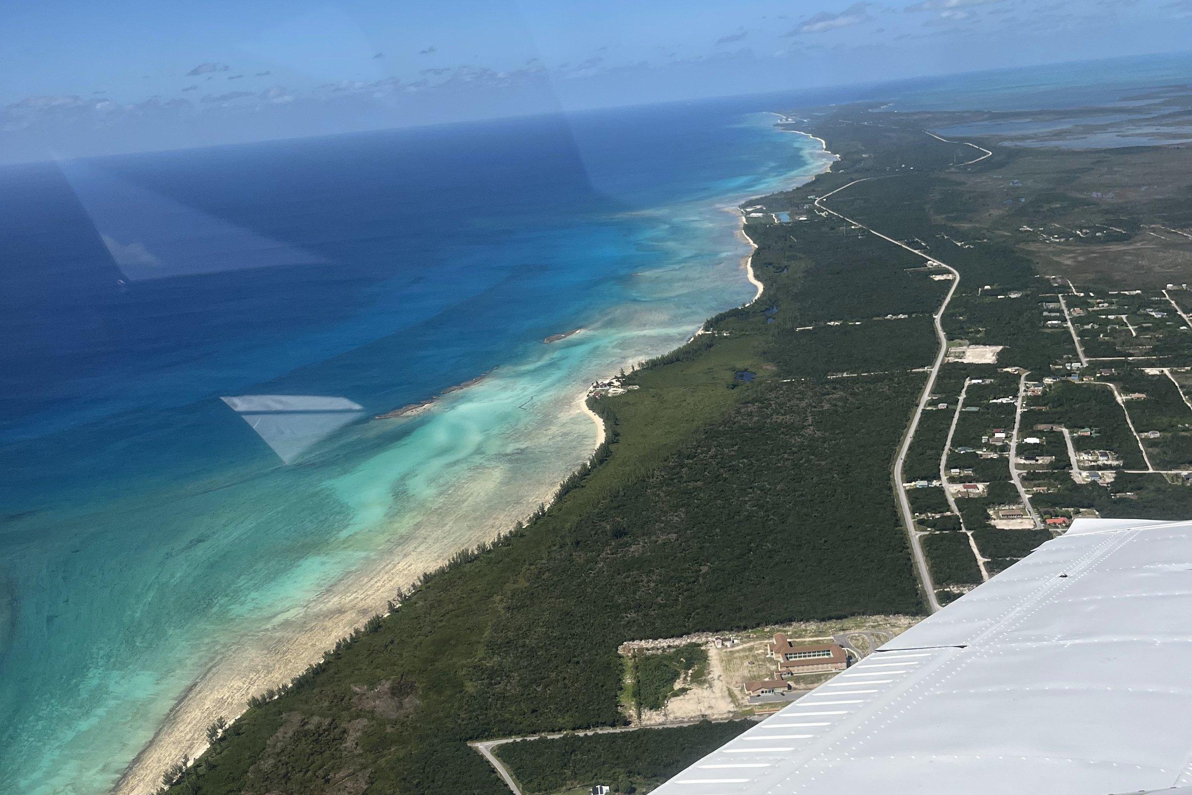 Descending over the Grand Bahama coastline, reef and settlement below the wing