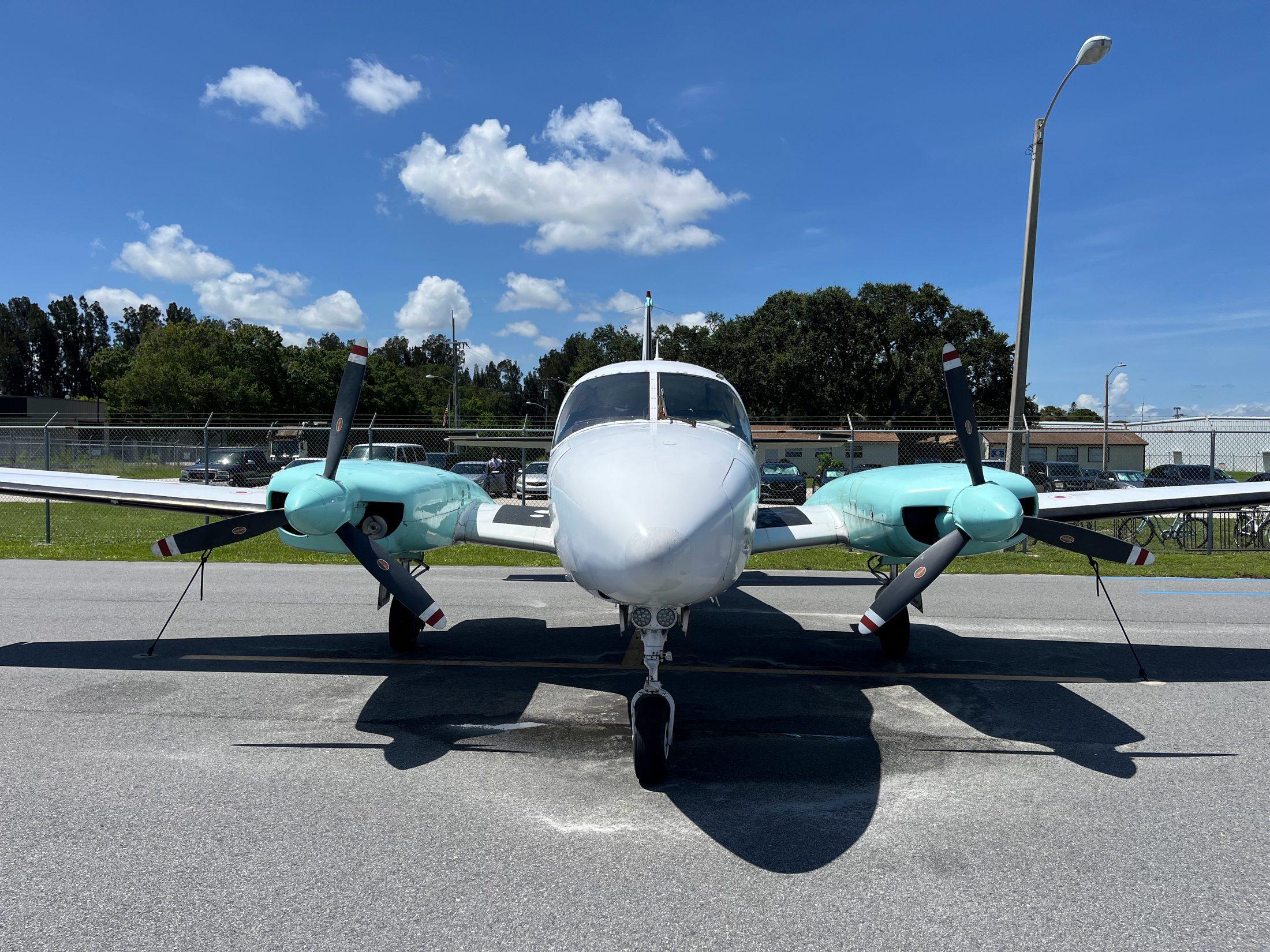 A Buzz Air twin-engine aircraft parked nose-on at the ramp under a blue Florida sky